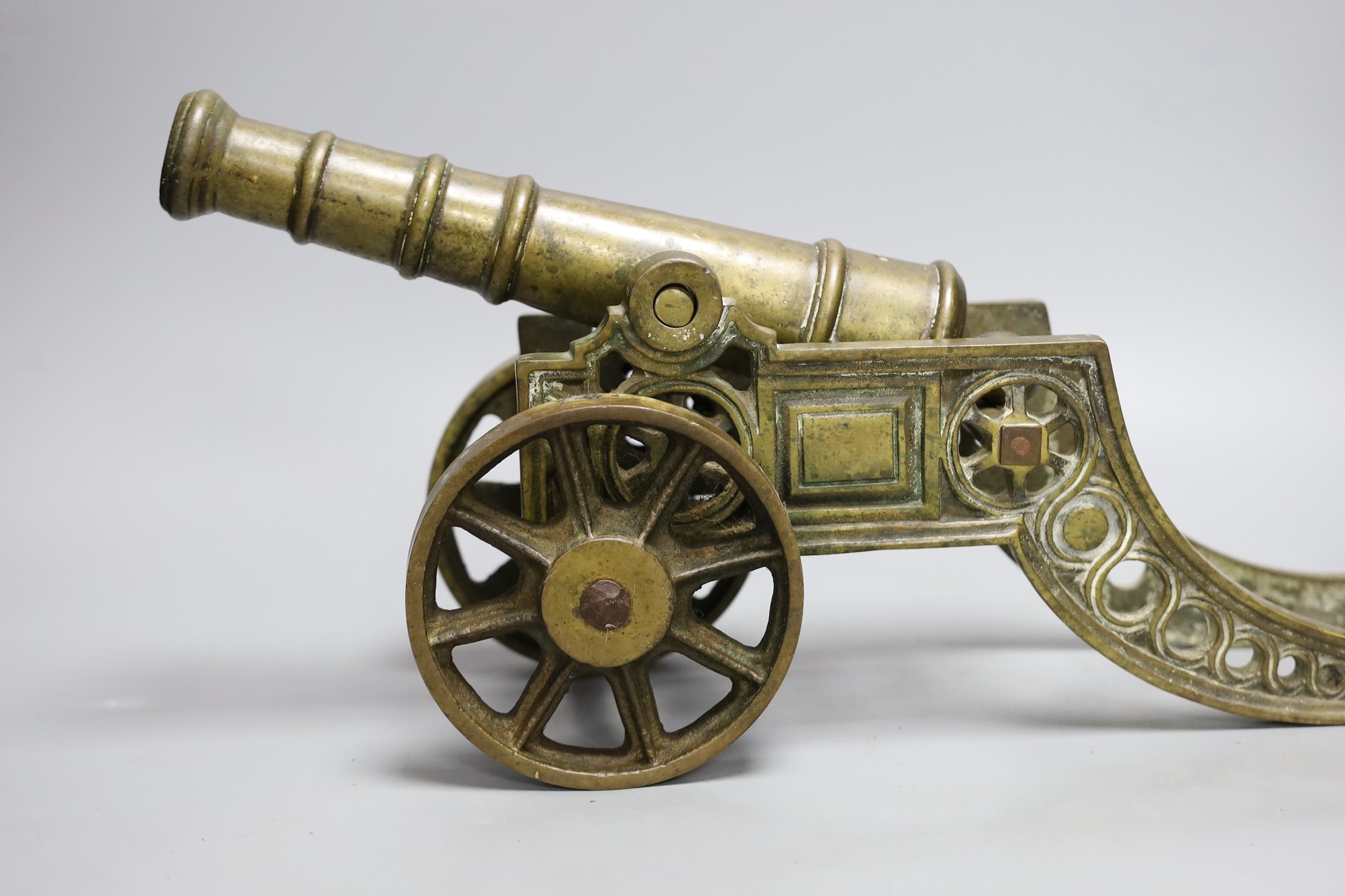 A cast bronze model of a cannon and a pair of cast brass sailors, cannon length 45cm